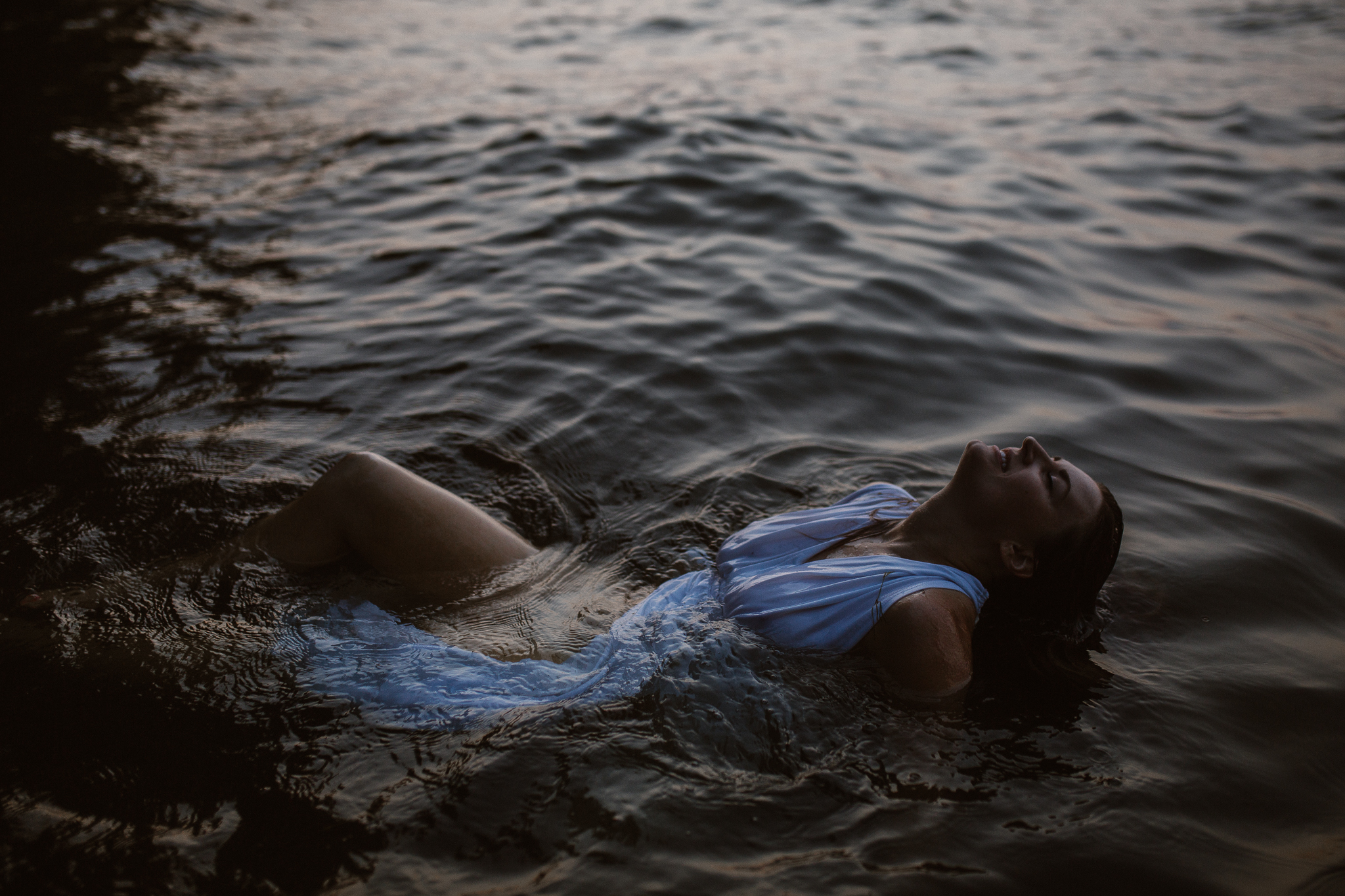 Captivating woman in an intimate lake session during a summer sunset.